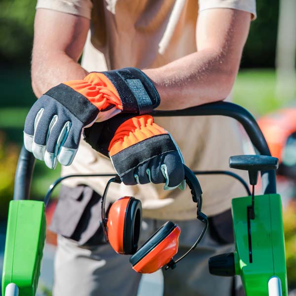 landscaper by law mower holding ear protection